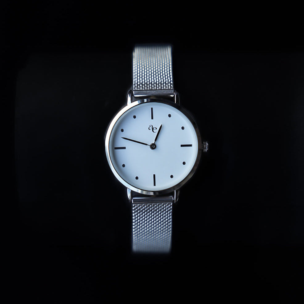 Silver watch with a white face on a black background